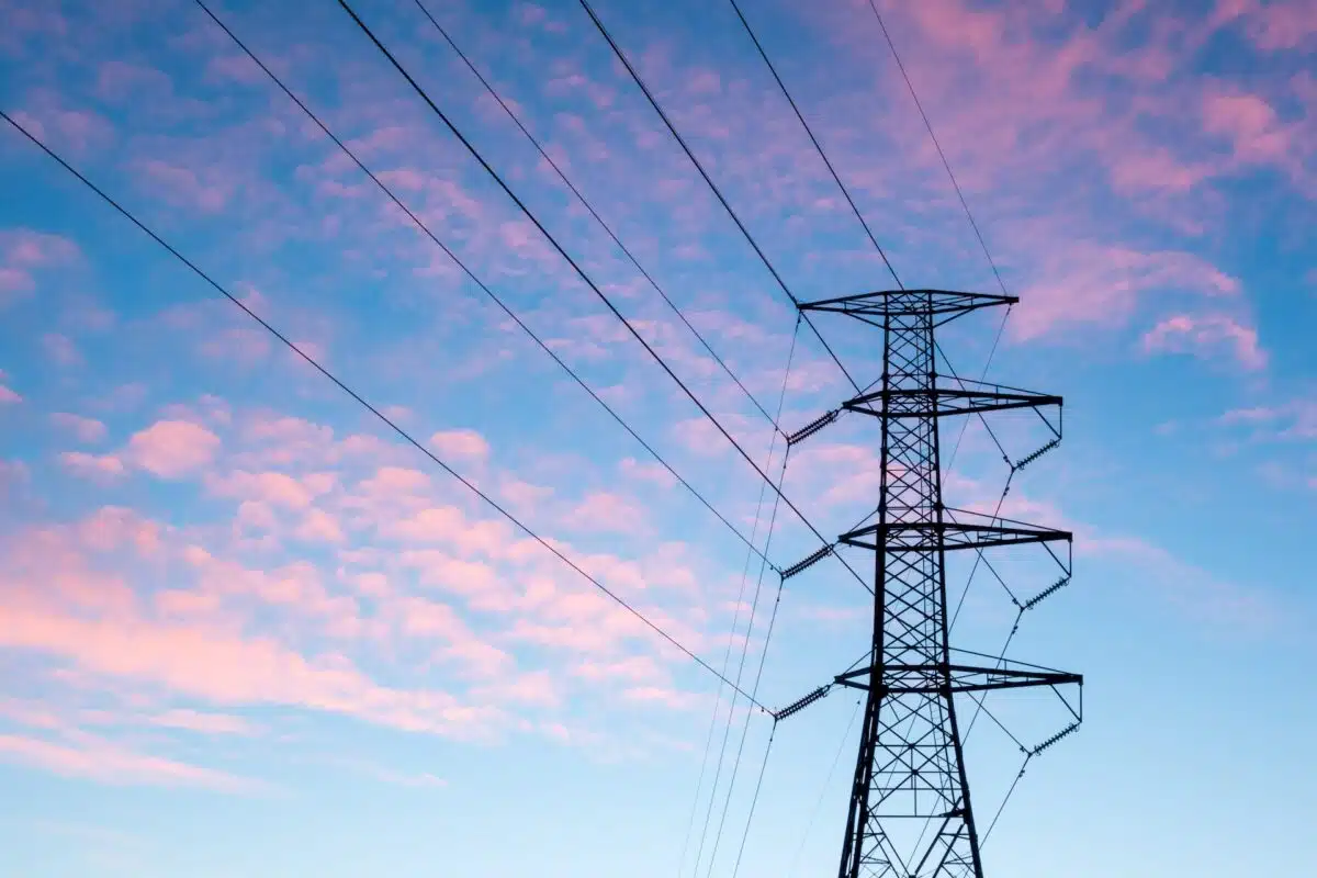 An electricity pylon against a sunset sky to represent the electricity grid